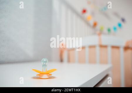 Succhietto per bambini sdraiato sul comodino, primo piano. Il concetto di genitorialità e pianificazione familiare. Foto Stock