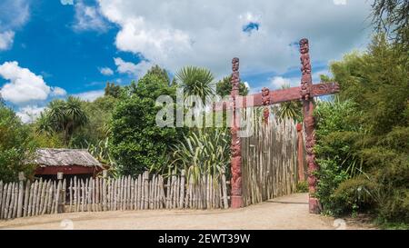 Esotico giardino Maori nativo con cancello rosso intagliato e. Capanna,Tiro Made in Nuova Zelanda Foto Stock