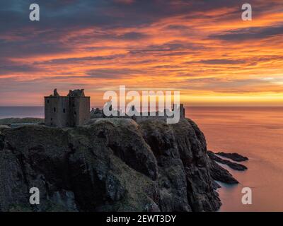 Un'alba ardente sulle rovine del castello di Dunnottar, Stonehaven, Aberdeenshire, Scozia, Regno Unito Foto Stock