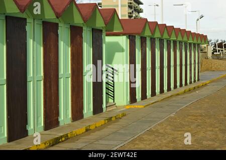 Capanne e cabine verdi sulla sabbia con porte in legno e tetti rossi (Pesaro, Italia, Europa) Foto Stock