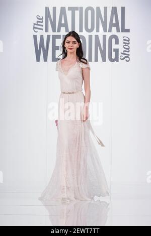 Modello nero femminile in abito lungo sulla pista al National Wedding Show, Londra Foto Stock