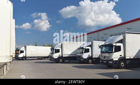 Camion che caricano ad un deposito di un'agenzia di spedizione - Trasporti e logistica nel commercio di merci Foto Stock