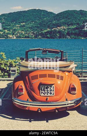 Betle vw convertibile arancione di fronte al Lago di Como, Italia Foto Stock