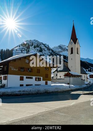 chiesa di Warth, Bregenzerwald con la montagna Karhorn sullo sfondo. Paese delle meraviglie invernali e meta di vacanza per sci e racchette da neve Foto Stock