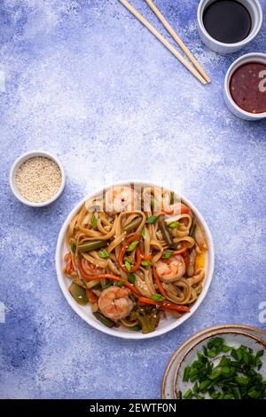 Wok con tagliatelle, gamberi e verdure Foto Stock