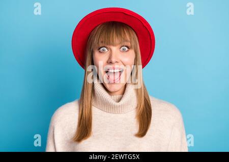 Ritratto foto ragazza stupita fissando bocca aperta in cappello rosso sorridente felice isolato sfondo di colore blu brillante Foto Stock