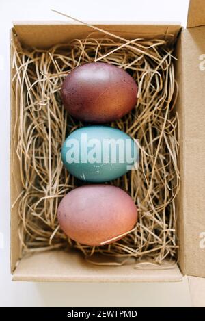 Pacchetto aperto con uova di Pasqua colorate. Foto vista dall'alto della vacanza concettuale Foto Stock