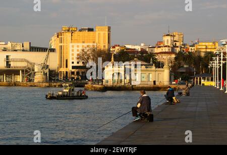 Piccolo pontile doppio da acqua superficie di pulizia società Urbaser nella baia di Santander Cantabria Spagna sole invernale Foto Stock