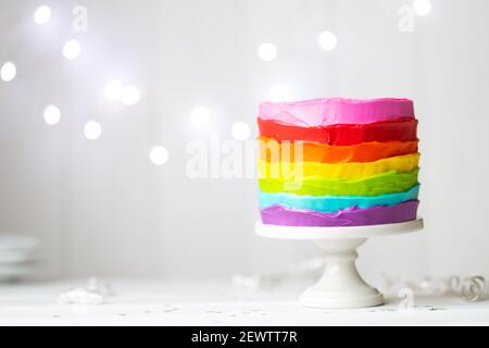 Torta arcobaleno colorata su un cakestand Foto Stock