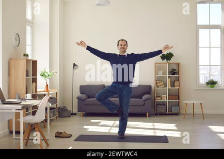 Operaio o uomo d'affari che pratica l'esercitazione di yoga durante la pausa al lavoro Foto Stock