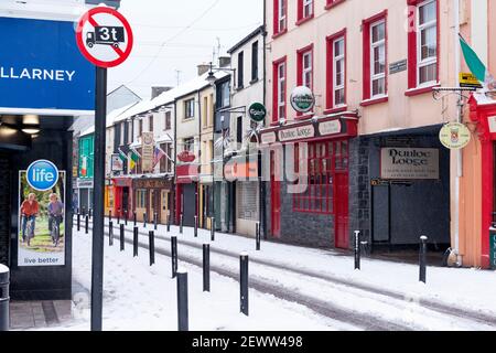 Negozi colorati, bar e ristoranti su College Street a Killarney, nella contea di Kerry, Irlanda, durante le forti nevicate e la tempesta "la bestia dell'Oriente" a marzo 2018 Foto Stock
