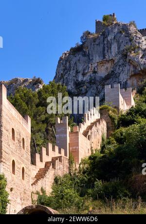 Immagine verticale parte del castello spagnolo di Xativa, frammento di muro fortificato contro la montagna rocciosa enorme fondo roccioso. Comunità Valenciana, Spagna Foto Stock