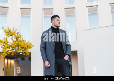 Uomo d'affari ben vestito in background industriale. Foto Stock