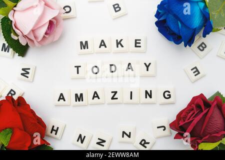 Faccia oggi citazione stupefacente sui blocchi di Alphabet e sui fiori sopra Sfondo bianco Foto Stock