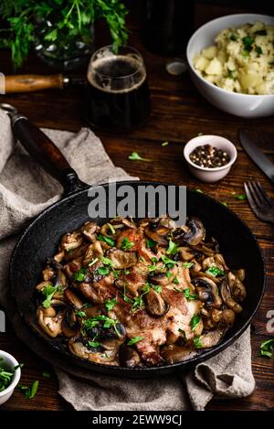 Bistecca di maiale fritta con funghi diversi e purè di patate Foto Stock