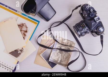 Vista dall'alto della fotocamera vintage retrò e delle vecchie fotografie. Foto Stock