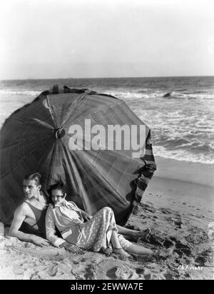 PHILLIPS HOLMES e SYLVIA SIDNEY su California Beach con spiaggia Ombrello 1931 Pubblicità Ritratto per Paramount Pictures Foto Stock