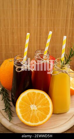 Limonata fatta in casa in piccole bottiglie. Succhi e frutta multicolore Foto Stock