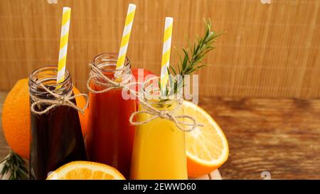 Limonata fatta in casa in piccole bottiglie. Succhi e frutta multicolore Foto Stock