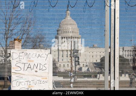 WASHINGTON D.C., STATI UNITI - Feb 25, 2021: Washington, D.C., USA- Febbraio 24th, 2020: Un segno che legge 'la democrazia si leva' fuori del surro di scherma Foto Stock