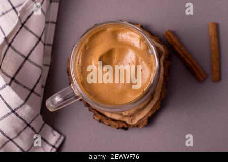 Caffè Dalgona. Vista dall'alto bevanda ghiacciata montata con caffè istantaneo popolare in Corea cocktail cremoso in una tazza trasparente in vetro a doppia parete contro la g Foto Stock