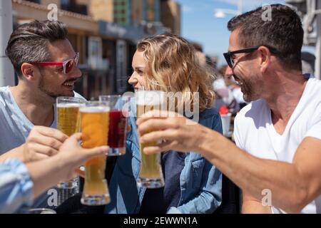 due coppie che inchiodano i bicchieri in un bar esterno Foto Stock