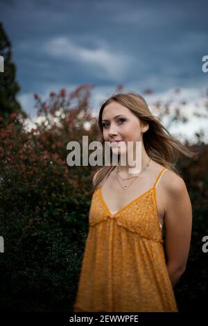 Una giovane donna in un abito si trova tra arbusti fioriti Con le Blue Ridge Mountains sullo sfondo Foto Stock