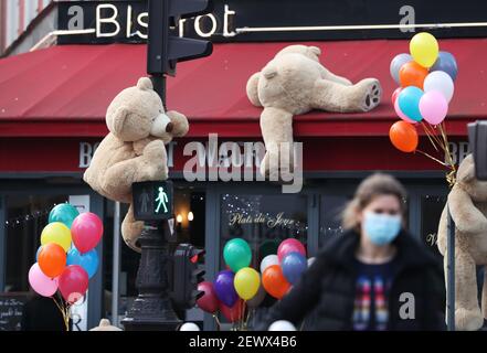 Parigi, gli orsi giganti del teddy sono visti in un ristorante che offre servizi di take away a Parigi. Ristoranti. 30 Ott 2020. Una donna passa davanti a un ristorante a Parigi, Francia, 3 marzo 2021. Gli orsacchiotti giganti sono visti in un ristorante che offre servizi di take away a Parigi. Ristoranti, bar e caffetterie sono stati tutti costretti a chiudere quando il paese è entrato nel suo secondo blocco il 30 ottobre 2020. Credit: Gao Jing/Xinhua/Alamy Live News Foto Stock