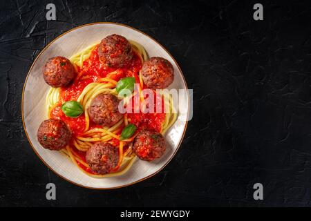 Polpette con spaghetti, foto in testa su nero con copyspace Foto Stock