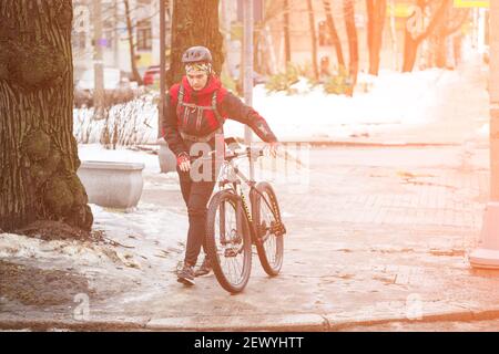 03.03.2021 Russia Vyborg giovane uomo attraversa la moto da strada accanto a sé. Foto di alta qualità Foto Stock