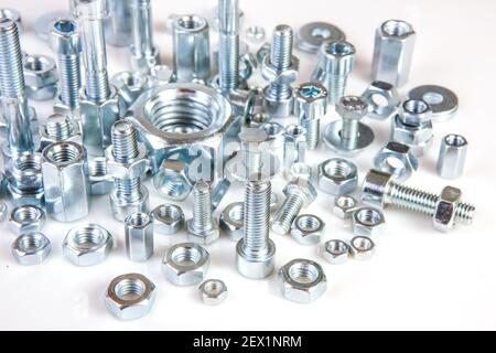 Chromeplated bulloni e dadi su sfondo bianco Foto Stock