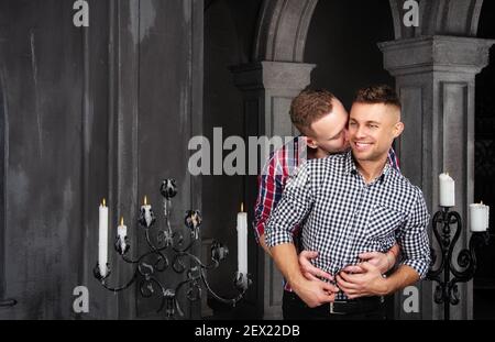 Giovane coppia gay felice sposarsi in chiesa. Amore e romanticismo. Bei uomini in abiti. Foto Stock