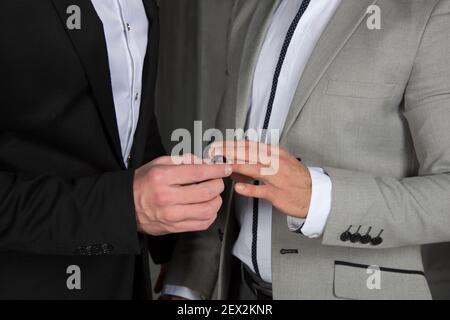 Giovane coppia gay felice sposarsi in chiesa. Amore e romanticismo. Bei uomini in abiti. Foto Stock