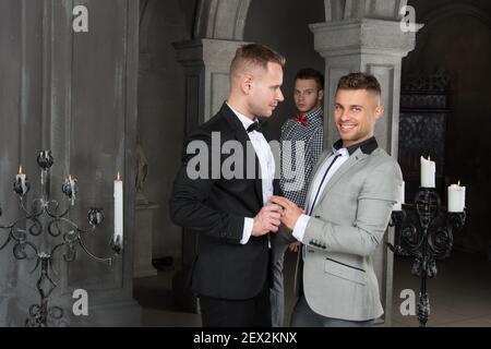 Giovane coppia gay felice sposarsi in chiesa. Amore e romanticismo. Bei uomini. Foto Stock