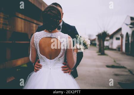 Una vista posteriore della sposa e dello sposo abbracciando Foto Stock