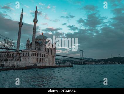 Vista panoramica della Moschea Ortakoy con il Ponte dei Martiri del 15 luglio a Istanbul, Turchia al tramonto Foto Stock
