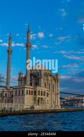 Vista verticale della Moschea Ortakoy con il 15 luglio Martiri Ponte a Istanbul, Turchia al tramonto Foto Stock