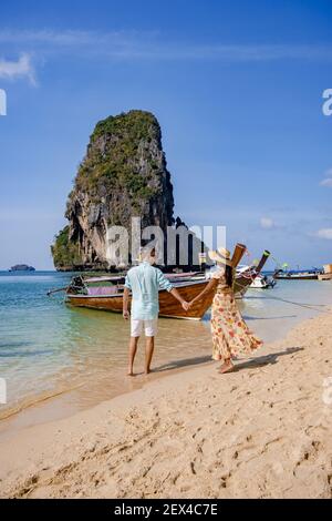 Coppia di mezza età su una spiaggia tropicale in Thailandia, turistica su una spiaggia tropicale bianca, Railay spiaggia con sullo sfondo barca a coda lunga. Railay Beach nella provincia di Krabi. Ao Nang, Thailandia. Foto Stock