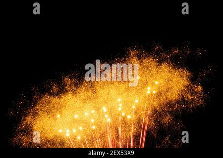 Immagine con sfondo nero preparata per modificare il testo di un fuochi d'artificio, formato da una moltitudine di piccoli punti di luce con molti più grandi in arancione. Foto Stock