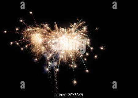 Immagine con sfondo nero preparata per la modifica del testo di un fuochi d'artificio, formato da una stella con diversi rami di colore bianco grezzo accompagnati da rosso e gr Foto Stock