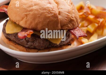 hamburger biologico fresco fattoria con pancetta e formaggio con casa patatine fritte fatte Foto Stock