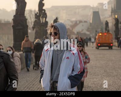 Praga, Repubblica Ceca. 03-02-2021. Ritratto di un giovane fresco a piedi, parlando e divertendosi sul Ponte Carlo nel centro della città di Prag Foto Stock