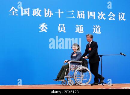 (210304) -- PECHINO, 4 marzo 2021 (Xinhua) -- Fan di'an (R), membro del tredicesimo Comitato nazionale della Conferenza consultiva politica popolare cinese (CPPCC), spinge Zhang Haidi, membro del tredicesimo Comitato nazionale del CPPCC, Sulla sua sedia a rotelle per aiutarla a lasciare dopo un'intervista via video link prima dell'apertura della quarta sessione del 13° Comitato Nazionale CPPCC alla Grande Sala del Popolo a Pechino, capitale della Cina, 4 marzo 2021. (Xinhua/li Muzi) Foto Stock