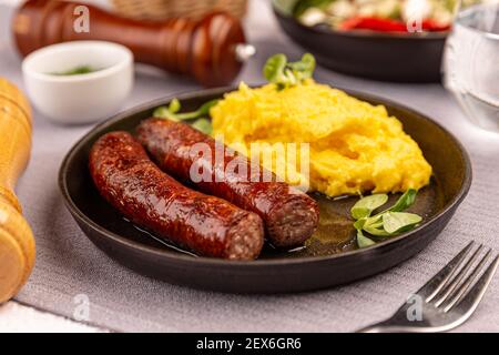 Salsicce di maiale alla griglia di mangalica servite con polenta al ristorante tabella Foto Stock