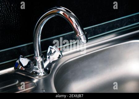 Doppio lavello e rubinetto nero su isola cucina contro piano cottura e  bancone Foto stock - Alamy