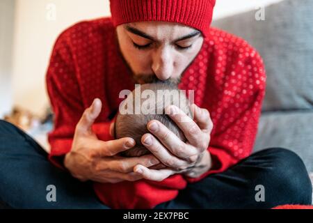 Foto di scorta dell'adorabile padre che bacia il suo bambino nel divano. Foto Stock