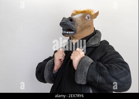 uomo in una maschera di cavallo. fuoco selettivo. cavallo sta portando un cappotto. prigioniero maschio Foto Stock