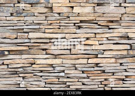 Muro di pietra di pietre naturali. Sfondo texture Brickwall.  Impiallacciature di pietra, parete di rivestimento in lastre impilate di  rocce naturali Foto stock - Alamy