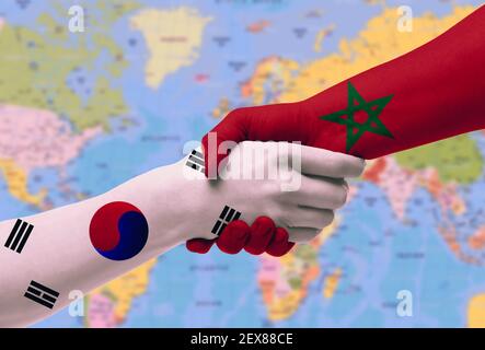 Stretta di mano tra marocco e Corea del Sud bandiere dipinte sulle mani, illustrazione con tracciato di ritaglio. Foto Stock