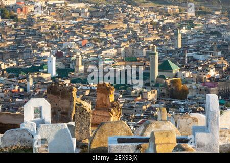 Vista panoramica del tramonto sulla medina Fes con lapidi del cimitero in primo piano, Tombe Marinide, Fes, Marocco Foto Stock